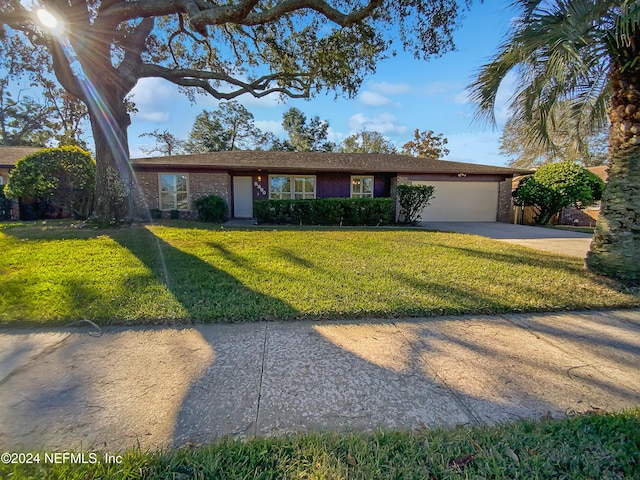 ranch-style house featuring a garage and a front lawn