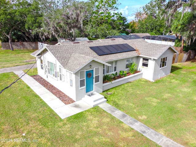 view of front facade featuring a front lawn and solar panels