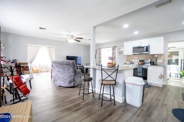 kitchen featuring white cabinets, appliances with stainless steel finishes, and a wealth of natural light