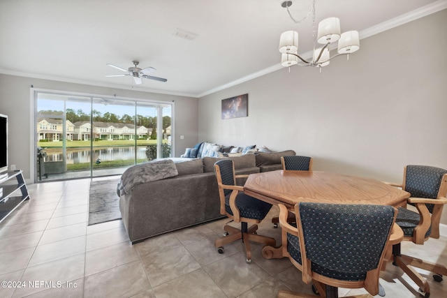 tiled dining area with ceiling fan with notable chandelier, a water view, and crown molding