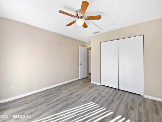 unfurnished bedroom featuring ceiling fan, light hardwood / wood-style floors, and a closet