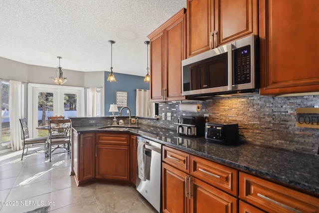 kitchen with sink, french doors, stainless steel appliances, tasteful backsplash, and pendant lighting