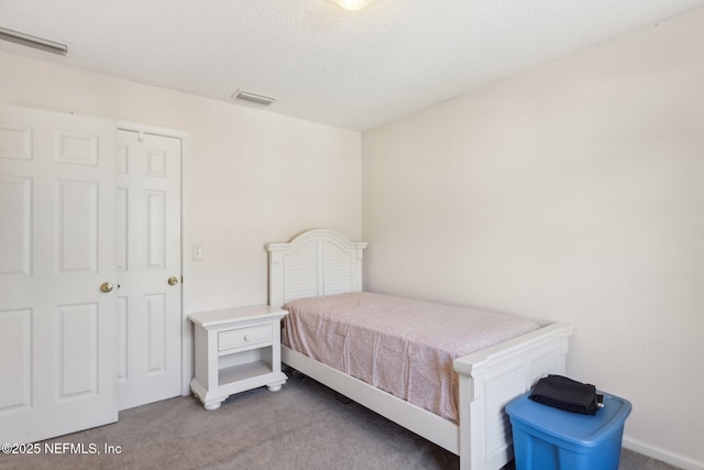 bedroom with light carpet and a textured ceiling