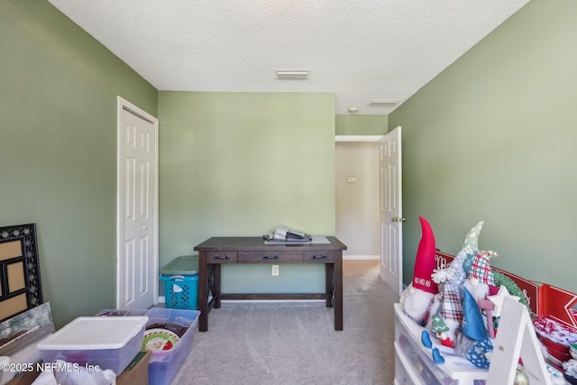 recreation room with a textured ceiling and light colored carpet