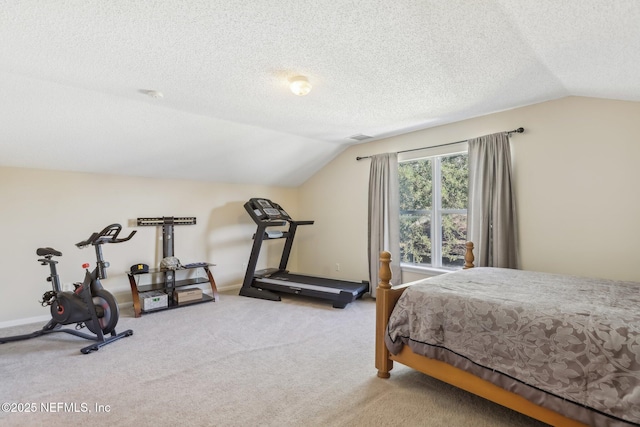 bedroom featuring a textured ceiling, carpet floors, and vaulted ceiling