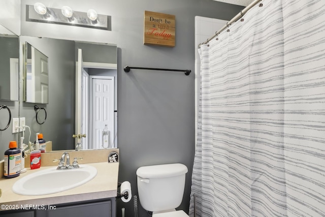 bathroom featuring vanity, toilet, and walk in shower