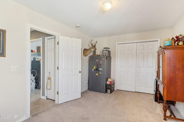 interior space featuring a textured ceiling and light colored carpet