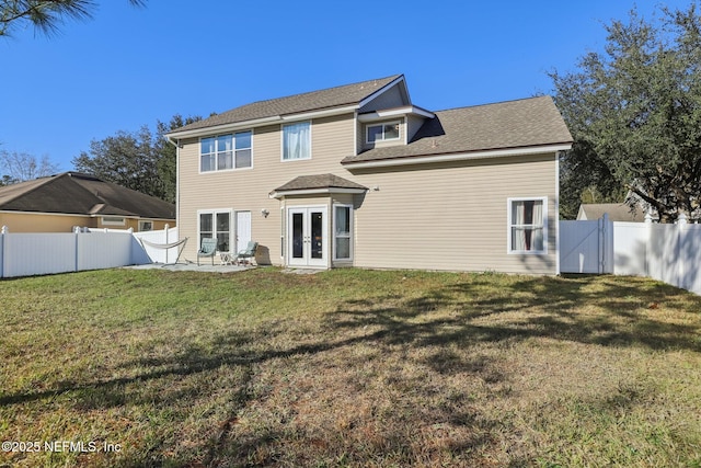 rear view of house featuring a yard, a patio, and french doors