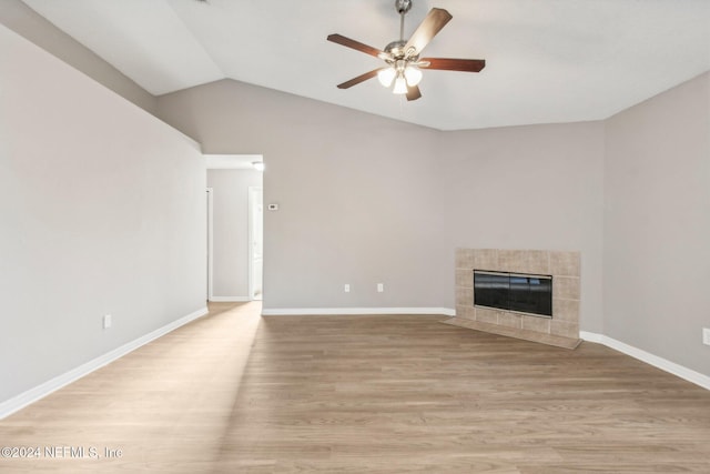 unfurnished living room with ceiling fan, light wood-type flooring, lofted ceiling, and a tiled fireplace