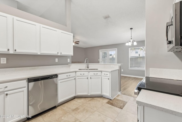 kitchen with kitchen peninsula, ceiling fan with notable chandelier, stainless steel appliances, white cabinetry, and hanging light fixtures