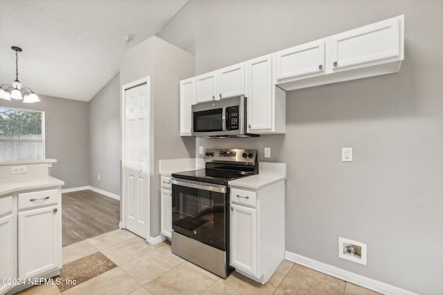 kitchen featuring white cabinets, stainless steel appliances, decorative light fixtures, and a notable chandelier