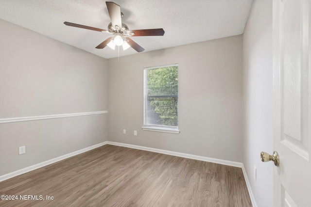 empty room with ceiling fan, light hardwood / wood-style floors, and a textured ceiling