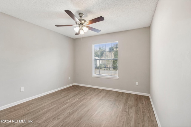 spare room with ceiling fan, a textured ceiling, and light wood-type flooring