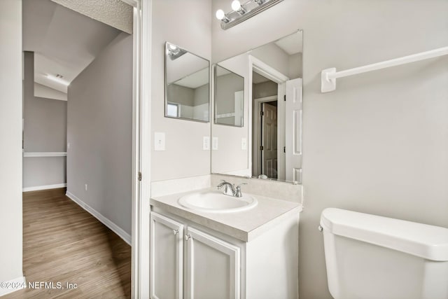 bathroom featuring hardwood / wood-style floors, vanity, and toilet