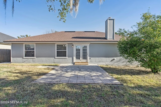 back of house featuring a lawn and french doors