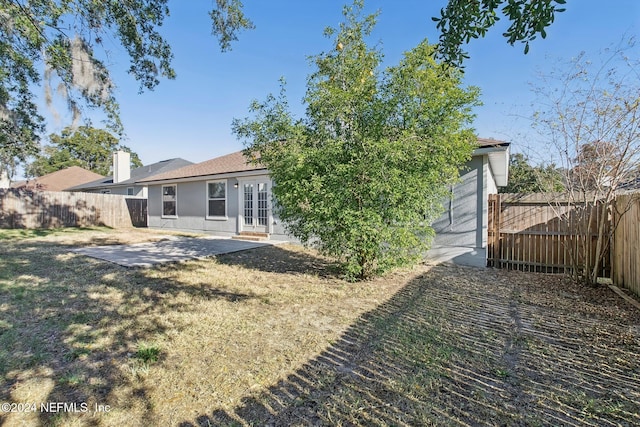 rear view of property with french doors, a yard, and a patio area