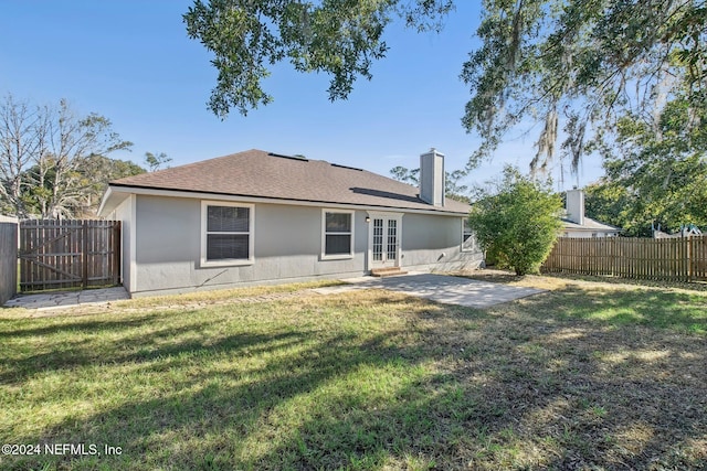 rear view of property with a lawn and a patio