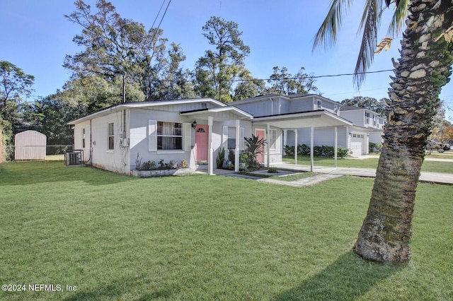 view of front of home with a storage unit, central air condition unit, and a front lawn