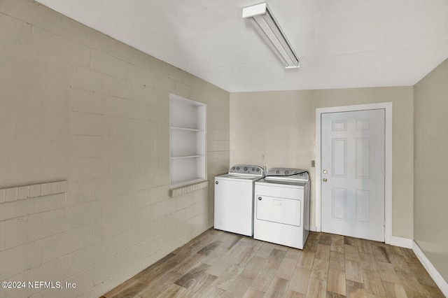 laundry area with light hardwood / wood-style floors and washing machine and dryer