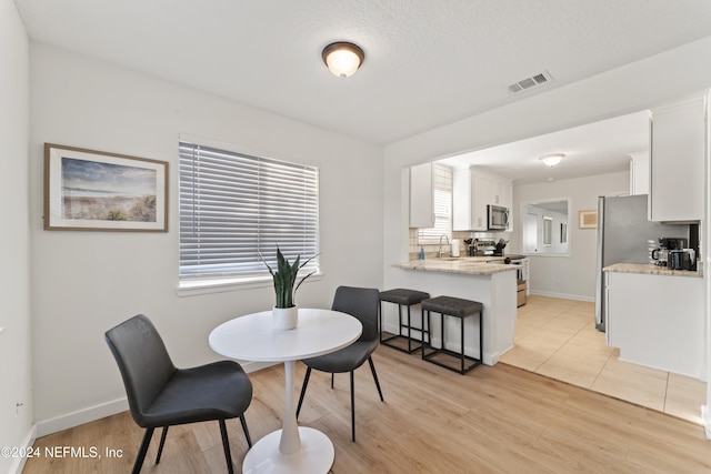 dining room featuring sink and light wood-type flooring