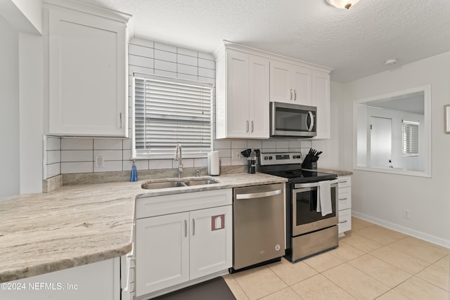 kitchen with white cabinetry, sink, backsplash, and appliances with stainless steel finishes