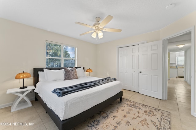 bedroom featuring light tile patterned floors, ceiling fan, and a closet