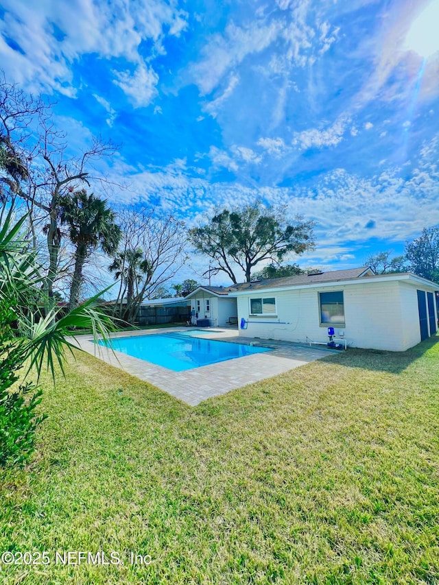 view of swimming pool featuring a patio and a lawn