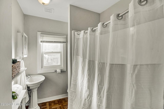 bathroom with parquet floors and a shower with shower curtain