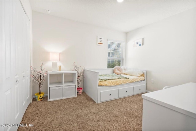 bedroom with light carpet and a closet