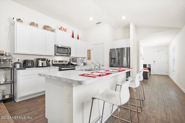 kitchen featuring white cabinets, appliances with stainless steel finishes, a kitchen island with sink, and sink