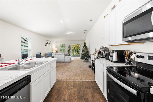 kitchen with dark wood-type flooring, white cabinets, sink, light stone counters, and stainless steel appliances