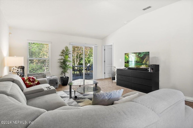 living room featuring light colored carpet and vaulted ceiling