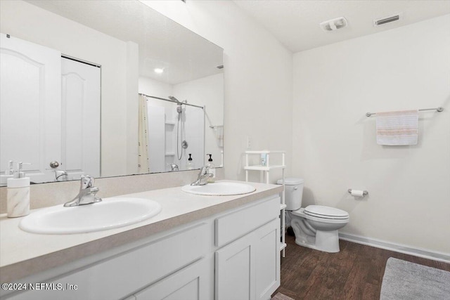 bathroom featuring toilet, vanity, wood-type flooring, and walk in shower