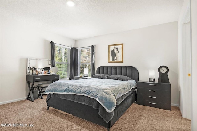 bedroom with light carpet and a textured ceiling