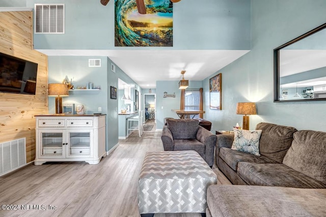 living room with light wood-type flooring and wooden walls