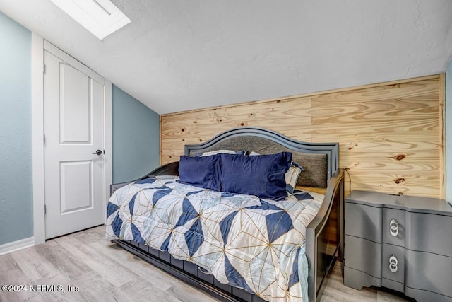 bedroom with hardwood / wood-style flooring and vaulted ceiling with skylight