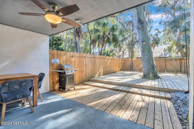 wooden deck with grilling area and ceiling fan