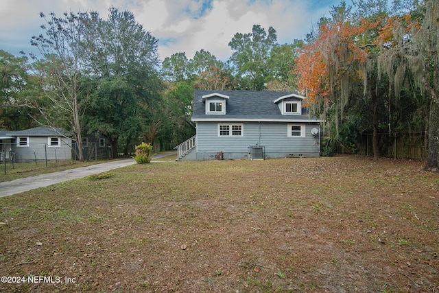 view of front of house featuring central air condition unit and a front yard