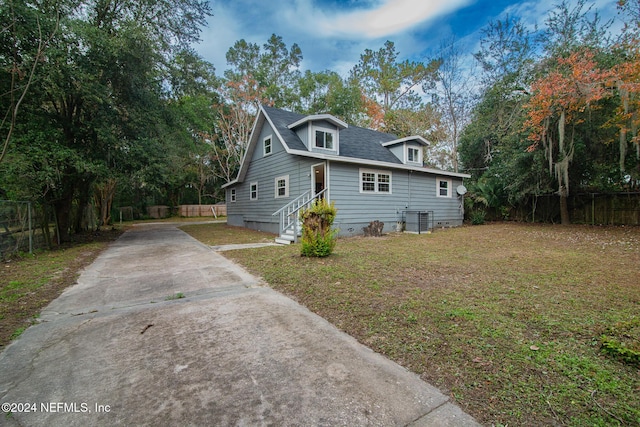 view of front of property with a front yard and cooling unit