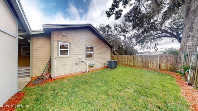 back of property featuring cooling unit and a lawn