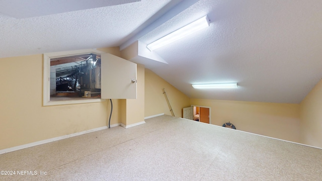 bonus room with a textured ceiling and vaulted ceiling