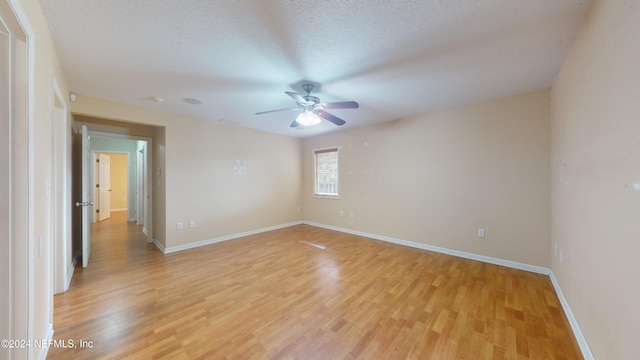 empty room featuring ceiling fan, light hardwood / wood-style floors, and a textured ceiling