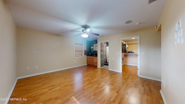 unfurnished living room featuring ceiling fan and light hardwood / wood-style floors