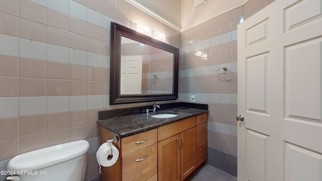 bathroom featuring tasteful backsplash, vanity, tile walls, and toilet