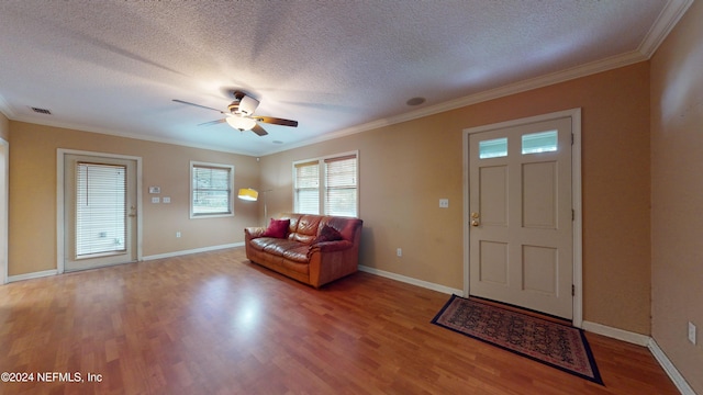 entryway featuring ceiling fan, crown molding, wood-type flooring, and a textured ceiling