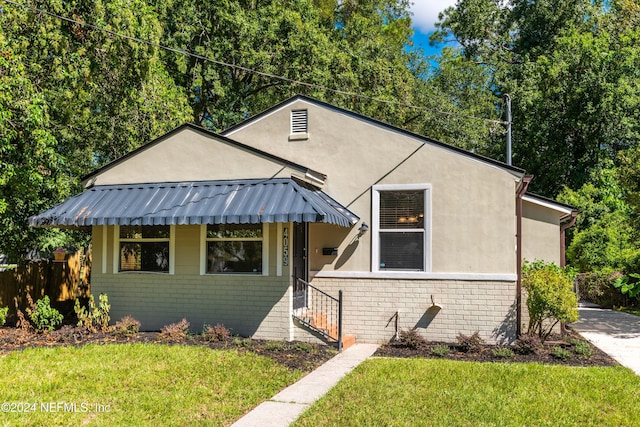 bungalow-style home featuring a front yard