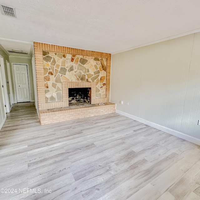 unfurnished living room featuring light hardwood / wood-style floors and a textured ceiling