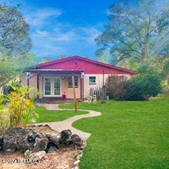 back of house featuring a yard and french doors