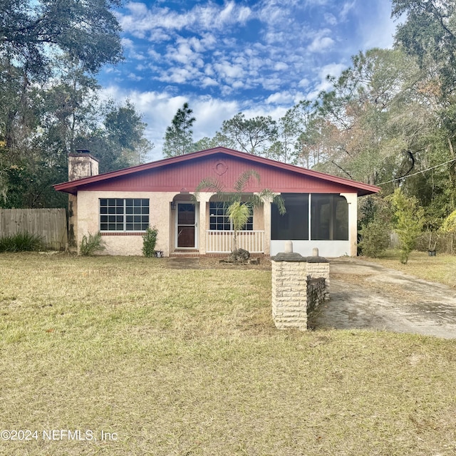 view of front of property featuring a sunroom and a front lawn