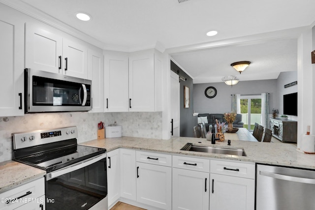 kitchen with light stone countertops, sink, tasteful backsplash, white cabinets, and appliances with stainless steel finishes